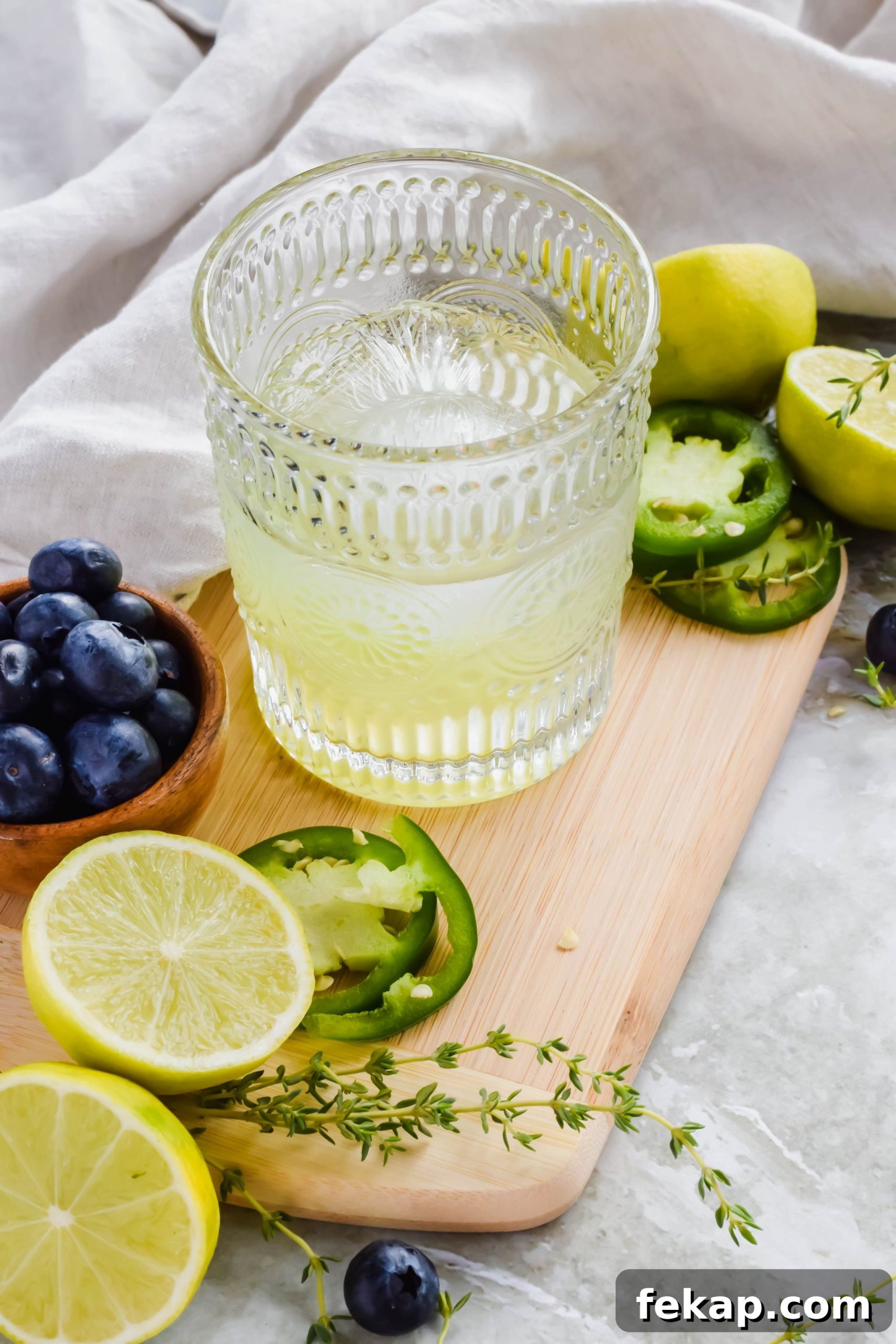 Blueberry Texas Ranch Water Cocktail Recipe 3 alcohol, lime, and jalapeño mixture for texas ranch water in cocktail glass.