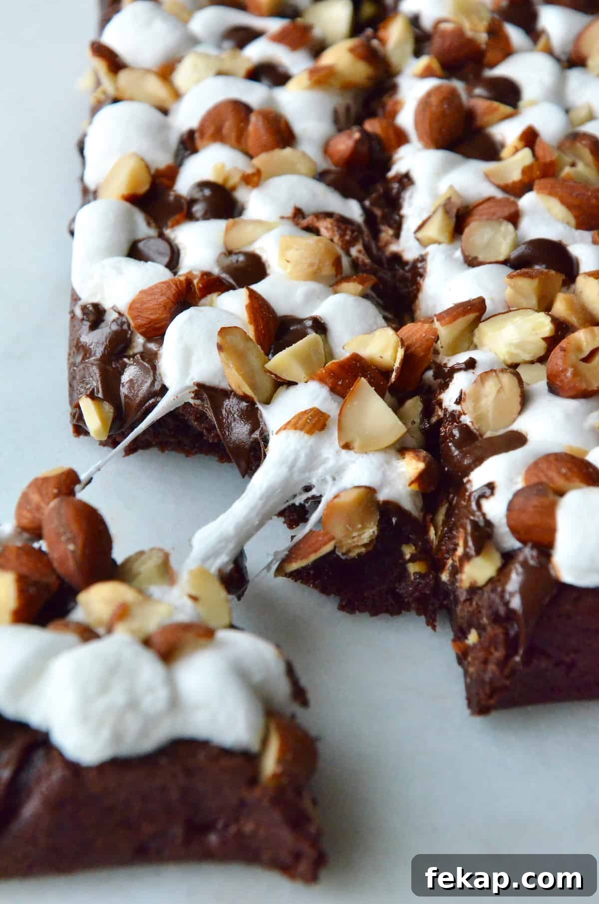 Fudgy Chocolate Brownies Recipe 16 Rock road brownies topped with chopped almonds. A piece of brownie is pulled off the corner.