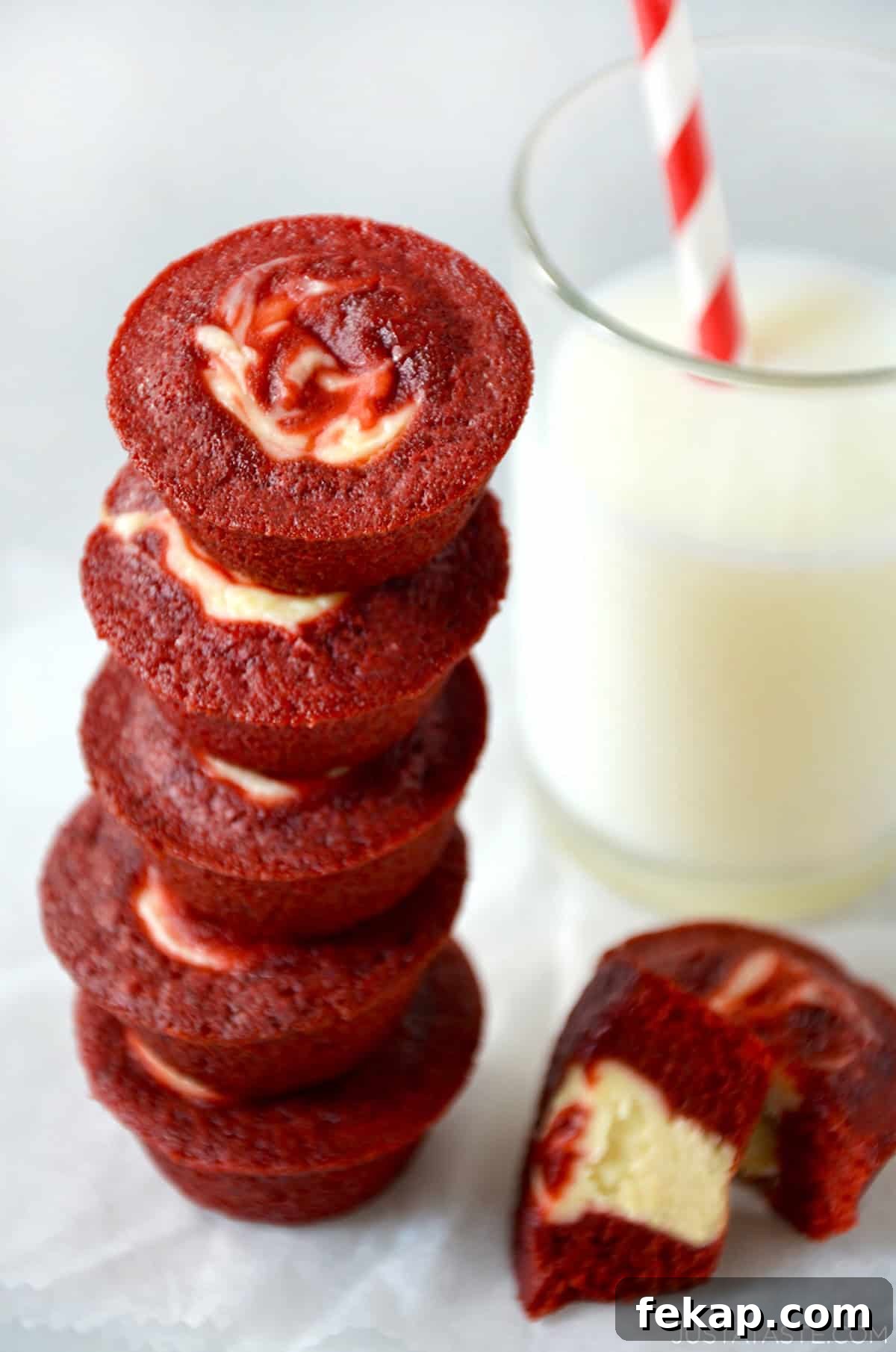 Fudgy Chocolate Brownies Recipe 10 Red velvet cheesecake brownie bites stacked five high next to a glass of milk.