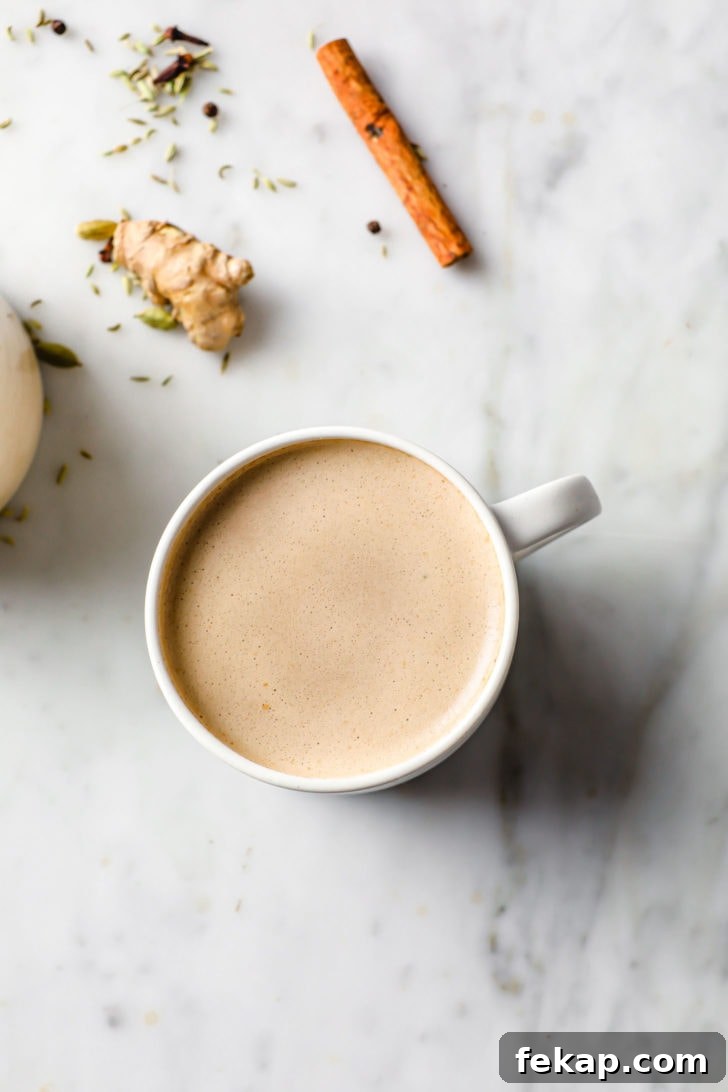 Authentic Masala Chai Recipe: Aromatic Spiced Tea 3 A slightly frothy chai (tea) in a white cup with froth on top