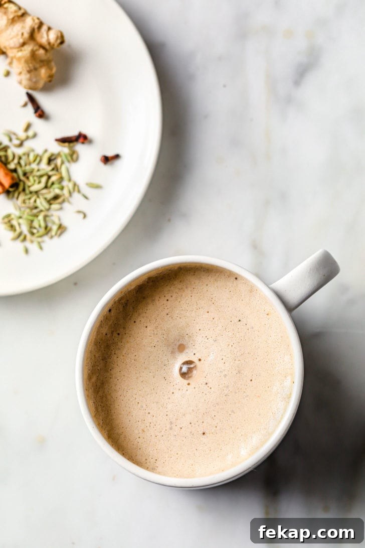 Authentic Masala Chai Recipe: Aromatic Spiced Tea 8 Frothed Chai Tea with a plate of spices on the side