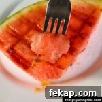 Grilled Watermelon on a fork over a piece of grilled watermelon