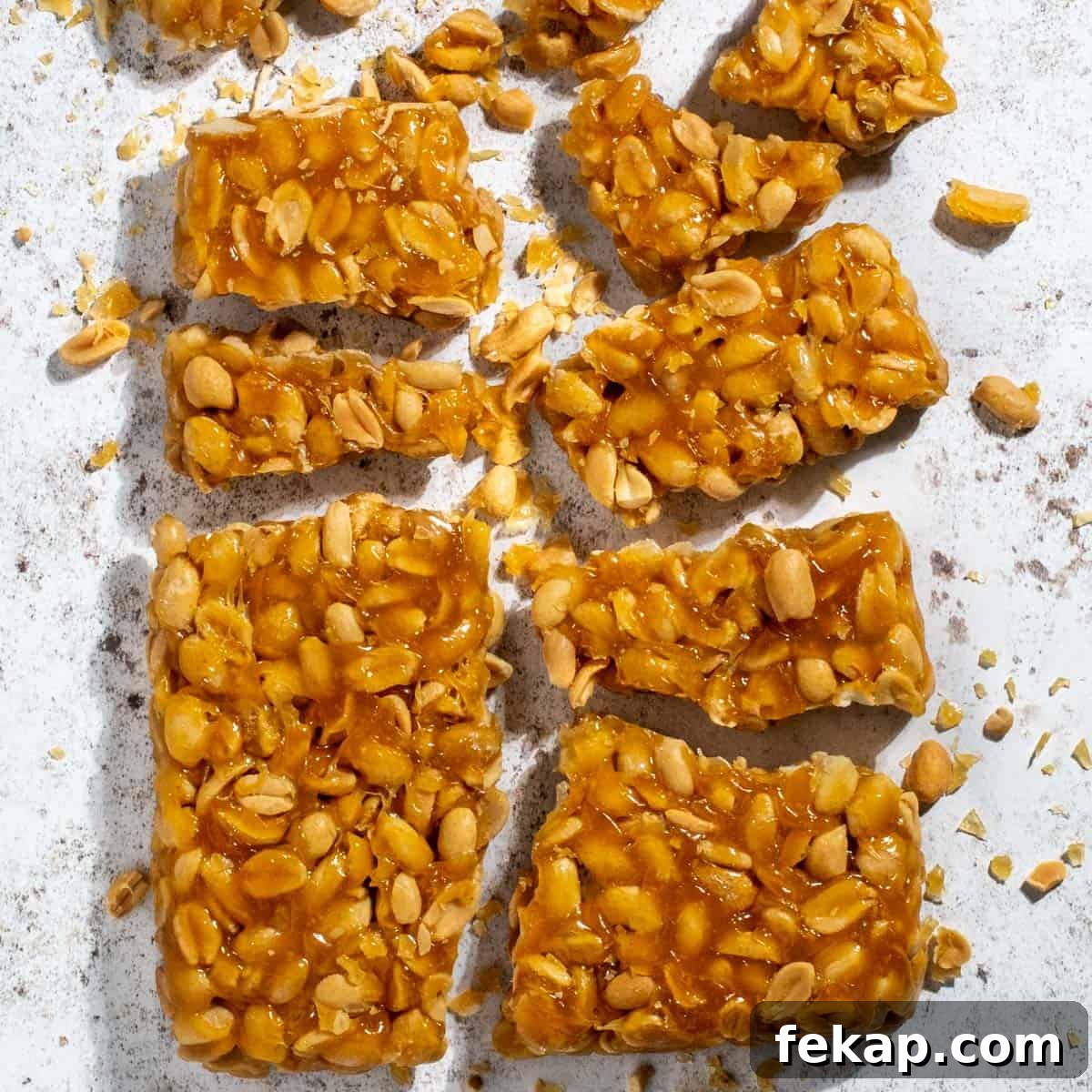 Peanut Brittle Without Corn Syrup 10 Peanut brittle without corn syrup broken into pieces on a white background.