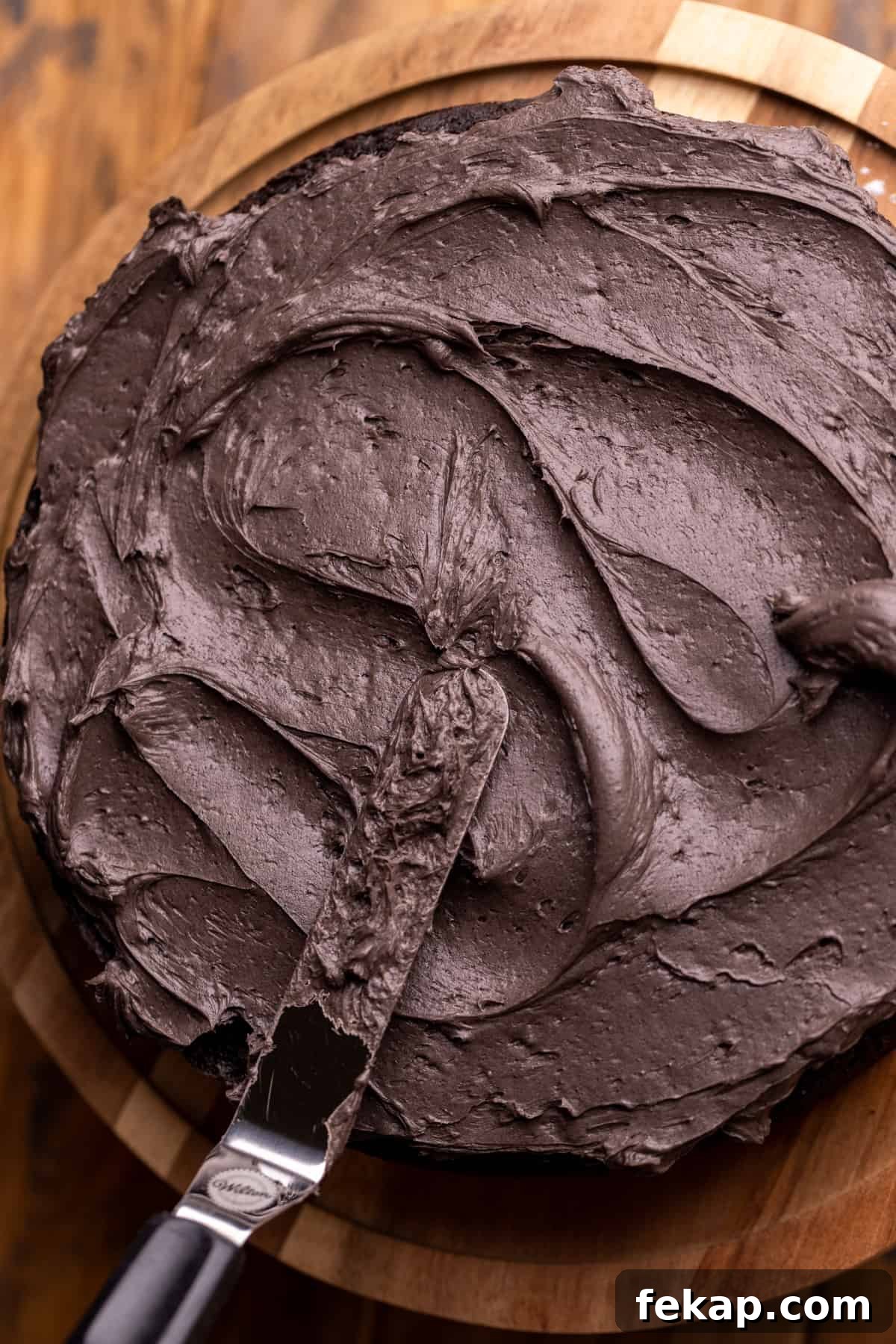 Spooky Halloween Chocolate Cake Recipe 9 Spreading black frosting on a cake.