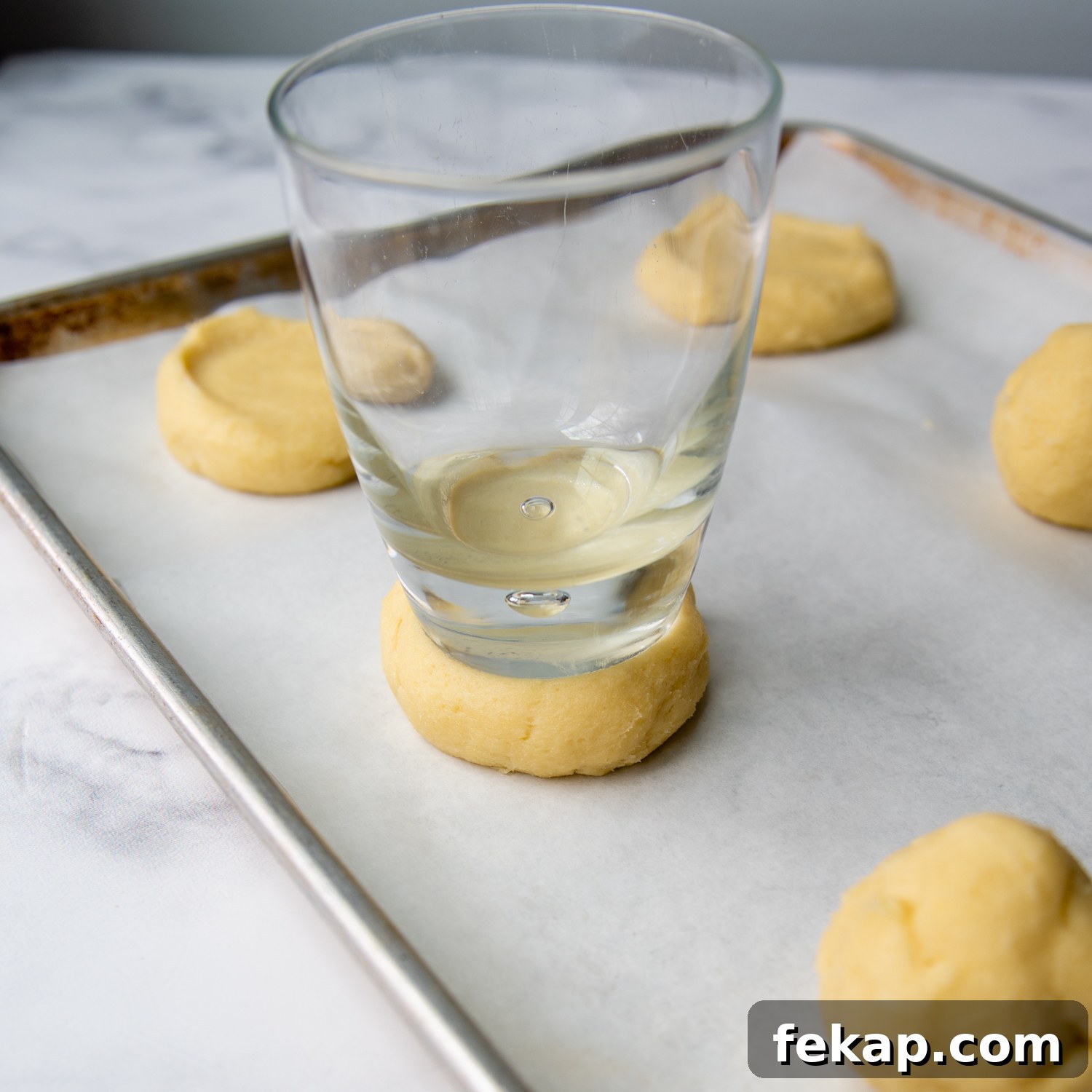 a glass flattening the dough.