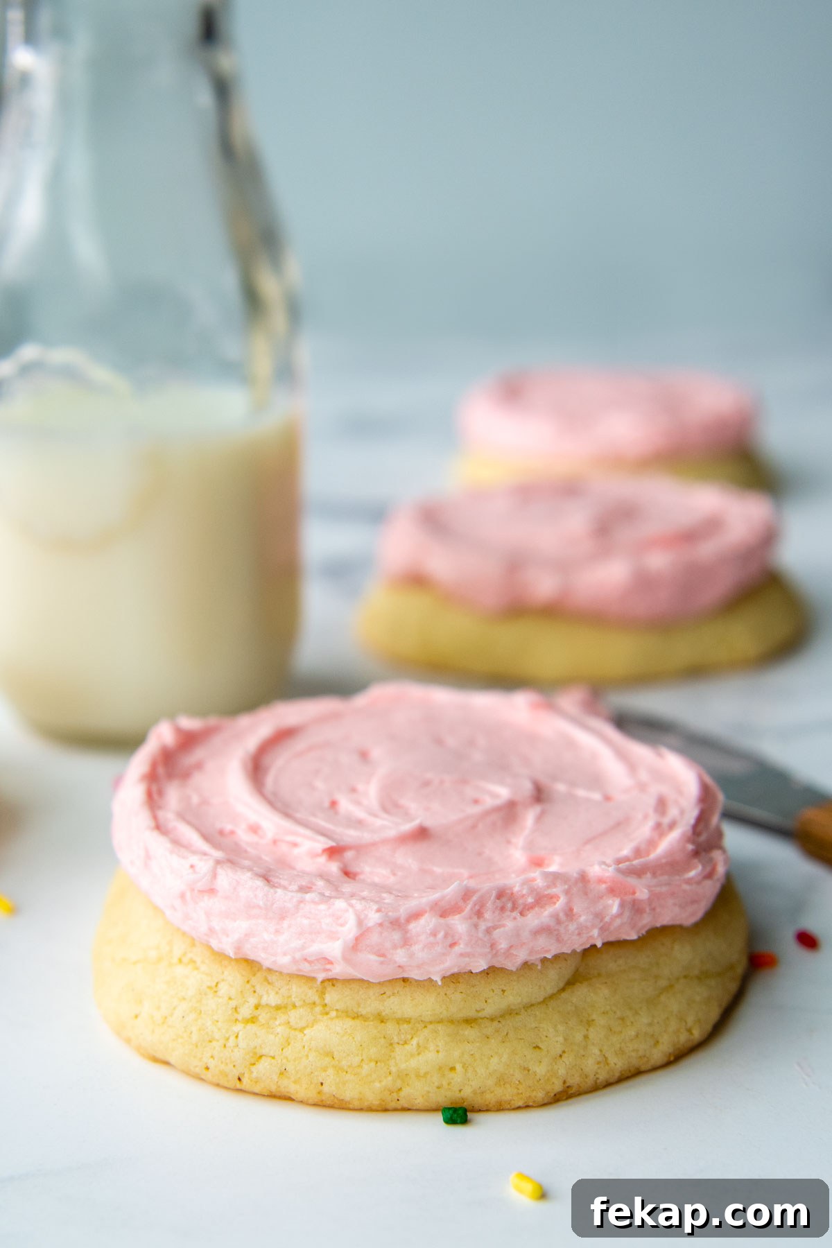 a close up straight on shot of a sugar cookie with pink frosting.