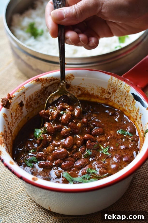 Instant Pot Rajma Masala is served in a white sauce pan with red rim