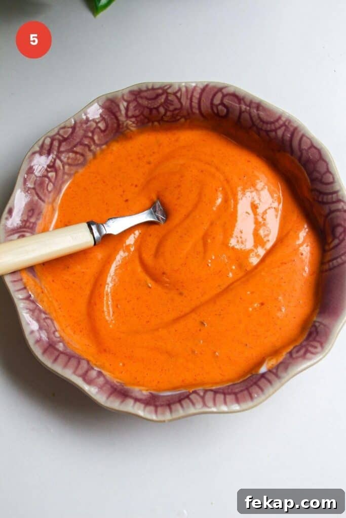 Spicy gochujang sauce in a pink bowl.