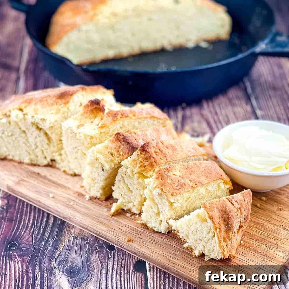 How to Make Irish Soda Bread Without Buttermilk 6 Half of the irish soda bread sliced on a wooden cutting board, with a small bowl of butter on the side.