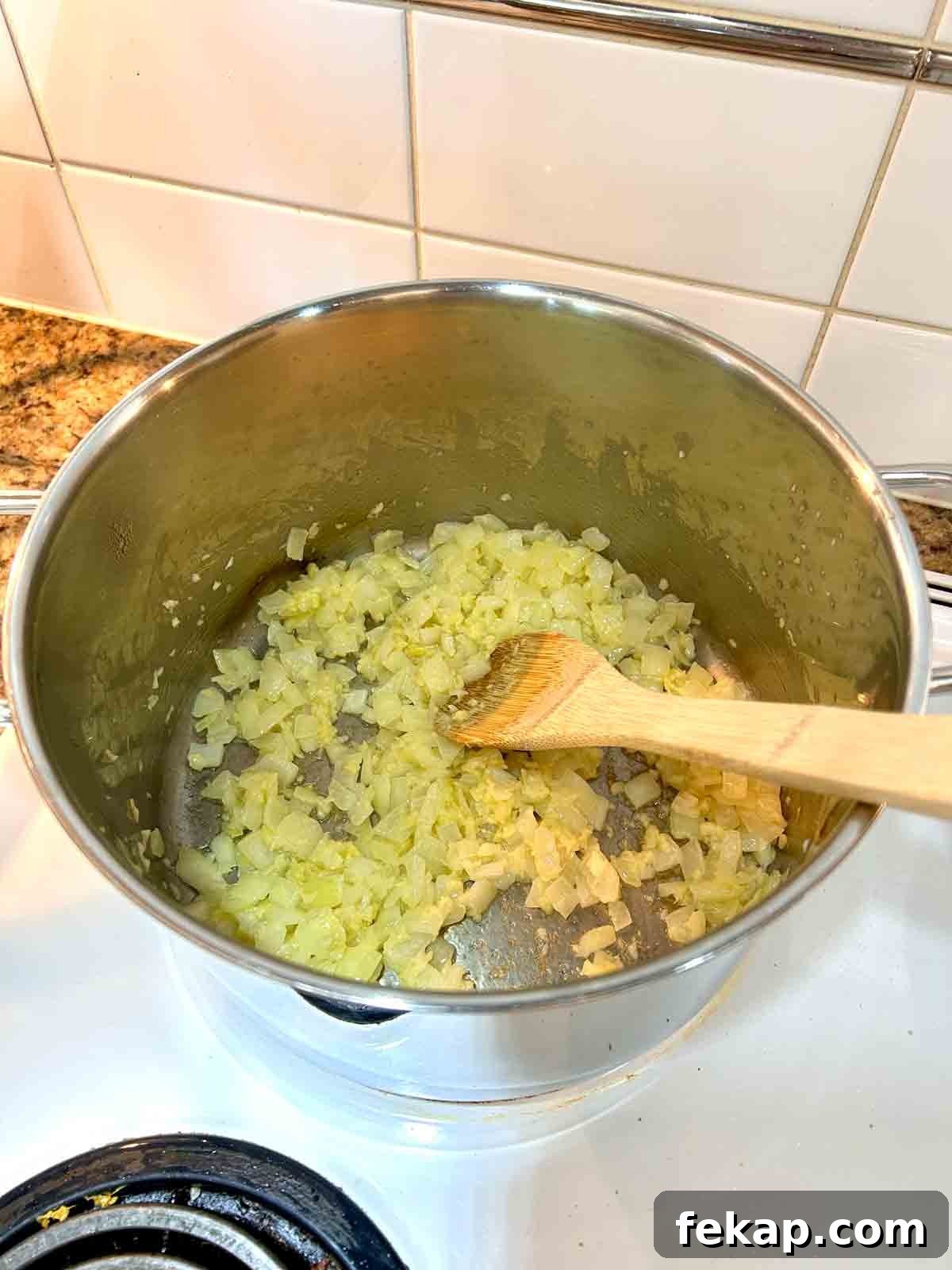 Creamy Butter Chicken Recipe: Authentic Indian Flavor 5 onions, garlic, and ginger being cooked in pot.