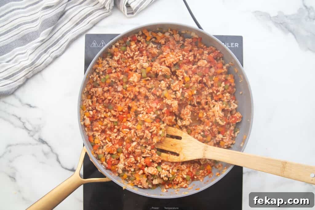 One Pan Stuffed Pepper Skillet Recipe 8 Ground chicken and vegetables simmering in a skillet.