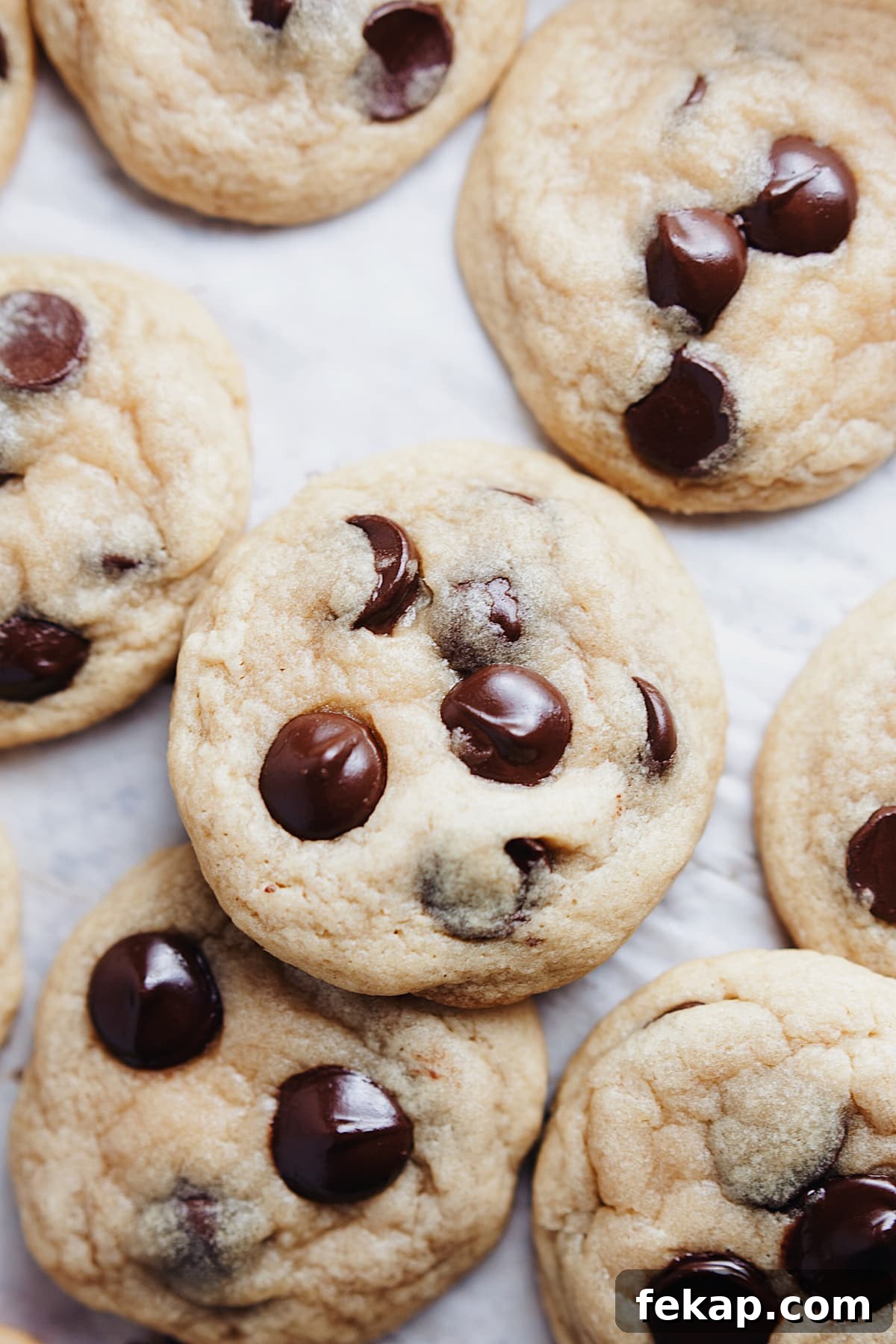 Chewy Ghirardelli chocolate chip cookies laid out on parchment paper.