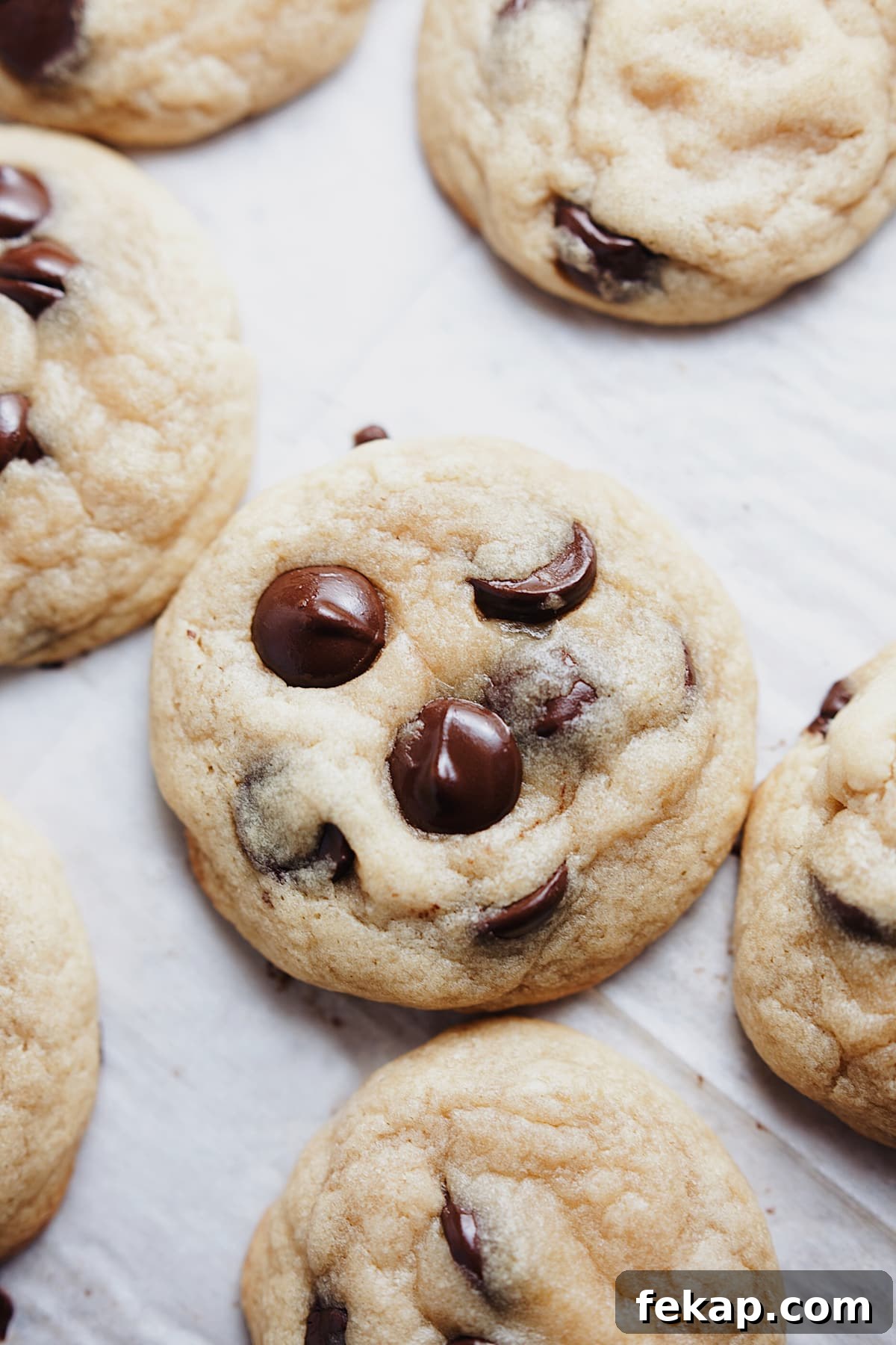 Chewy chocolate chip cookies laid out on parchment paper.