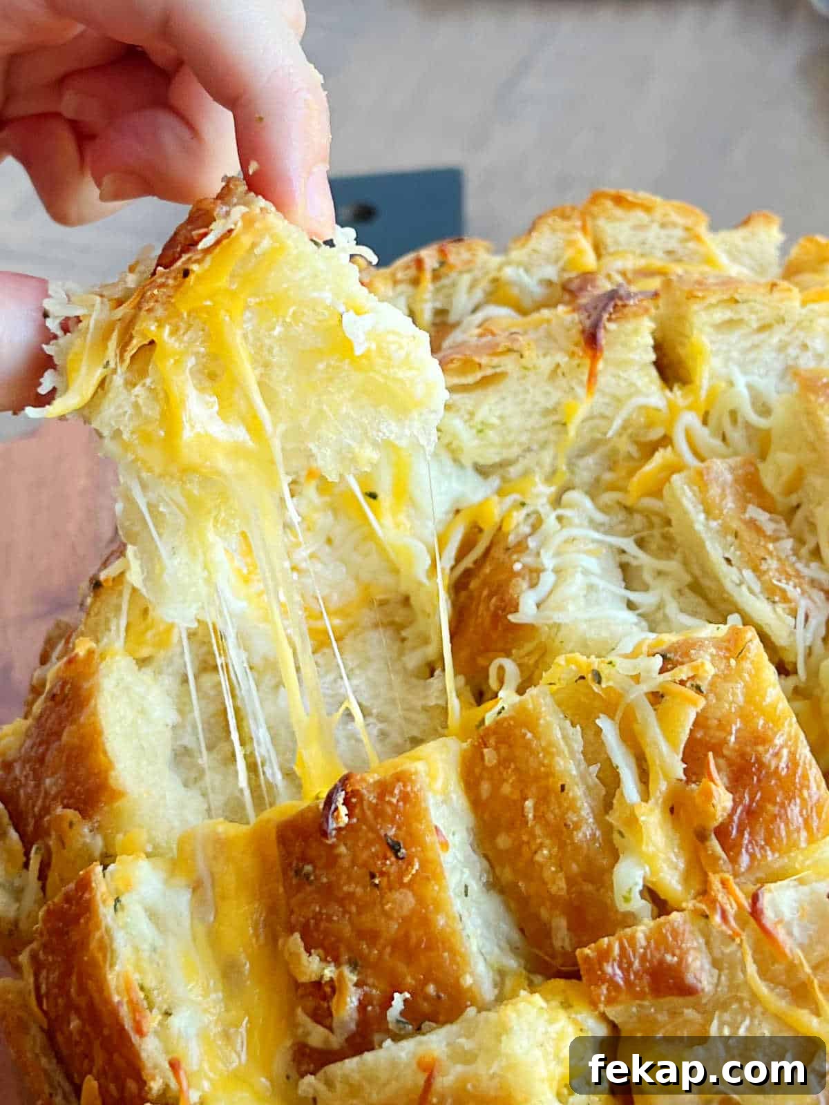 Garlic Herb Cheesy Pull-Apart Bread Recipe 2 cheesy pull apart bread with garlic butter and stretchy mozzarella in hand.