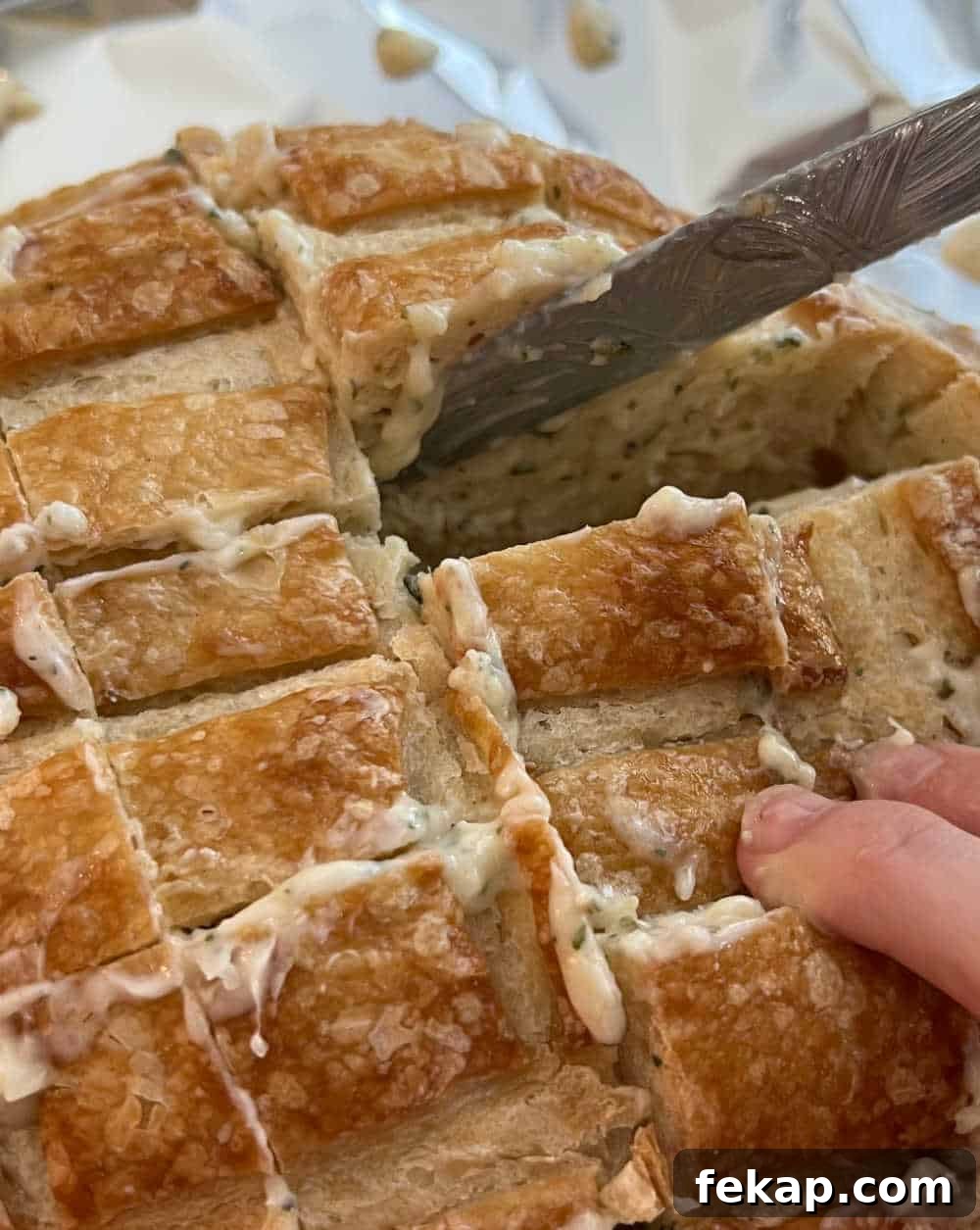 Garlic Herb Cheesy Pull-Apart Bread Recipe 5 spread garlic butter over bread loaf.