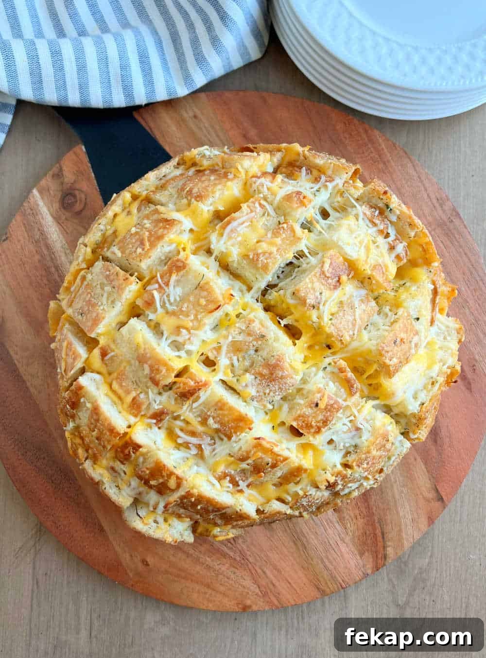 Garlic Herb Cheesy Pull-Apart Bread Recipe 7 baked garlic bread loaf stuffed with melted cheese on cutting board.