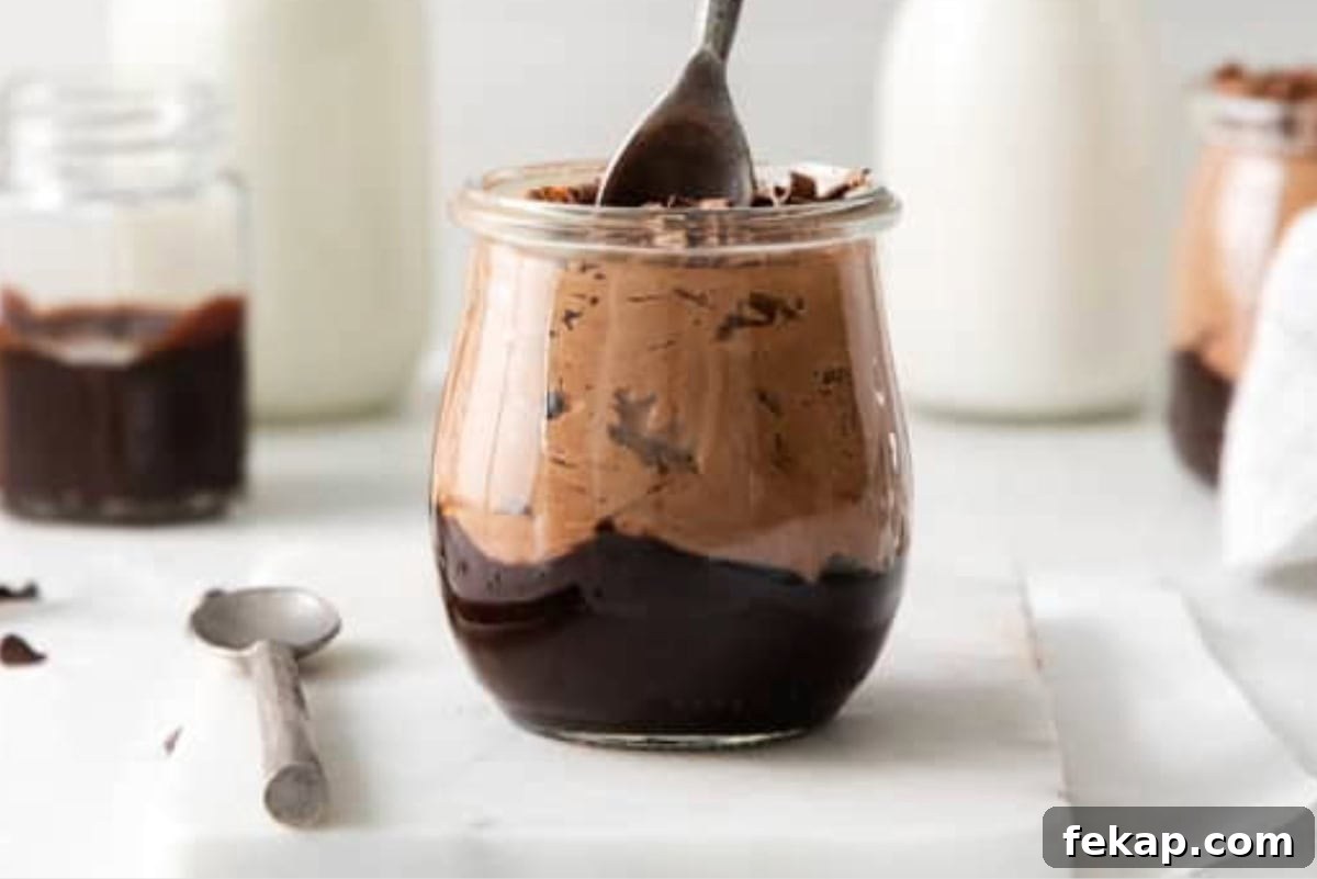How to Make Chocolate Cheesecake Mousse Cups 15 Spoon dipping into a cup of chocolate cream cheese mousse.