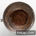 How to Make Chocolate Cheesecake Mousse Cups 7 powdered sugar and cocoa added to no bake chocolate cheesecake batter in a stainless mixing bowl.