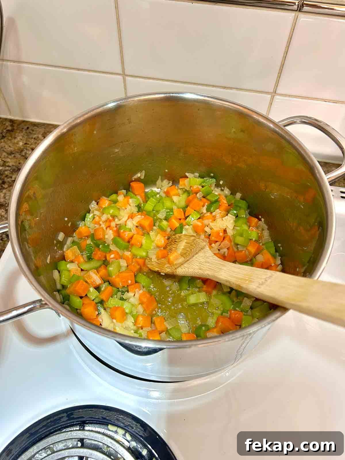 vegetables being sautéed in pot.
