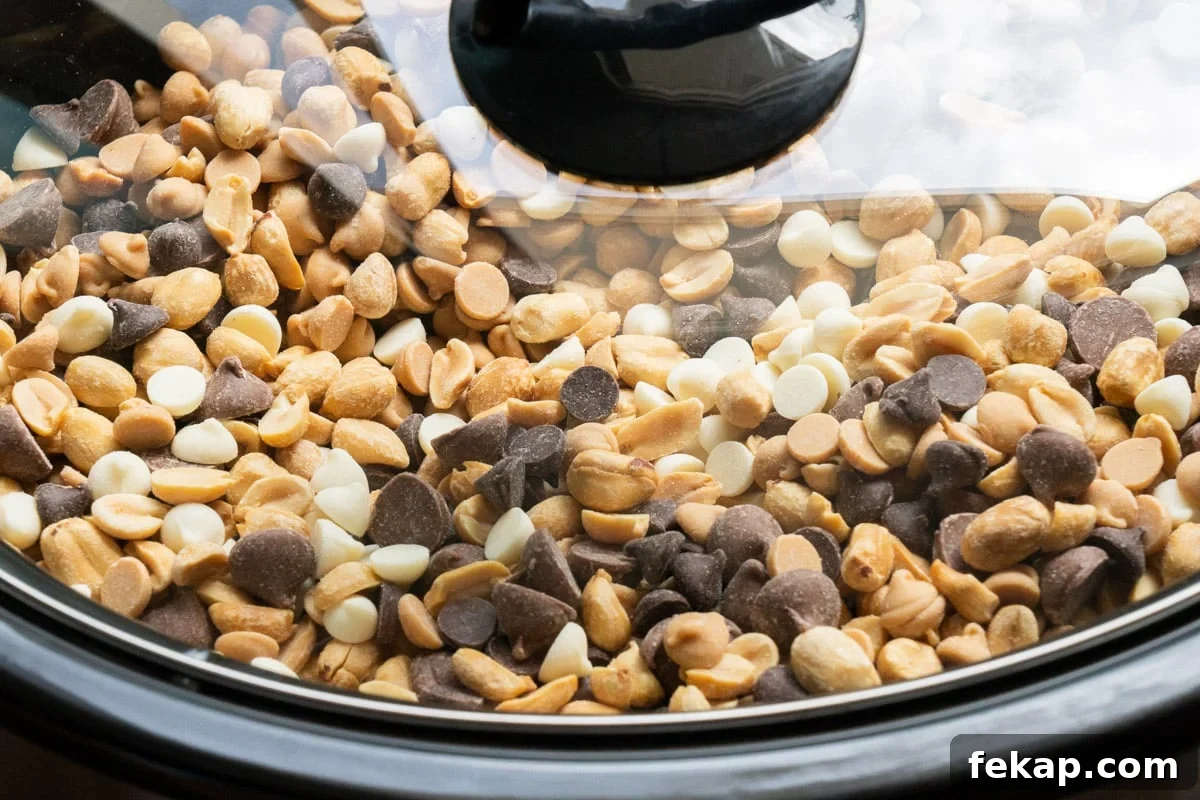 Slow Cooker Peanut Clusters Recipe 5 lid on slow cooker with peanuts and chocolate chips in it