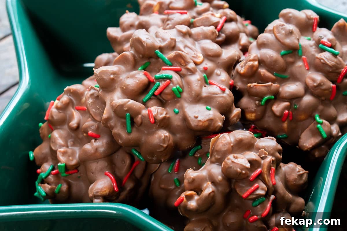 Slow Cooker Peanut Clusters Recipe 8 green bowl full of peanut clusters with red and green sprinkles