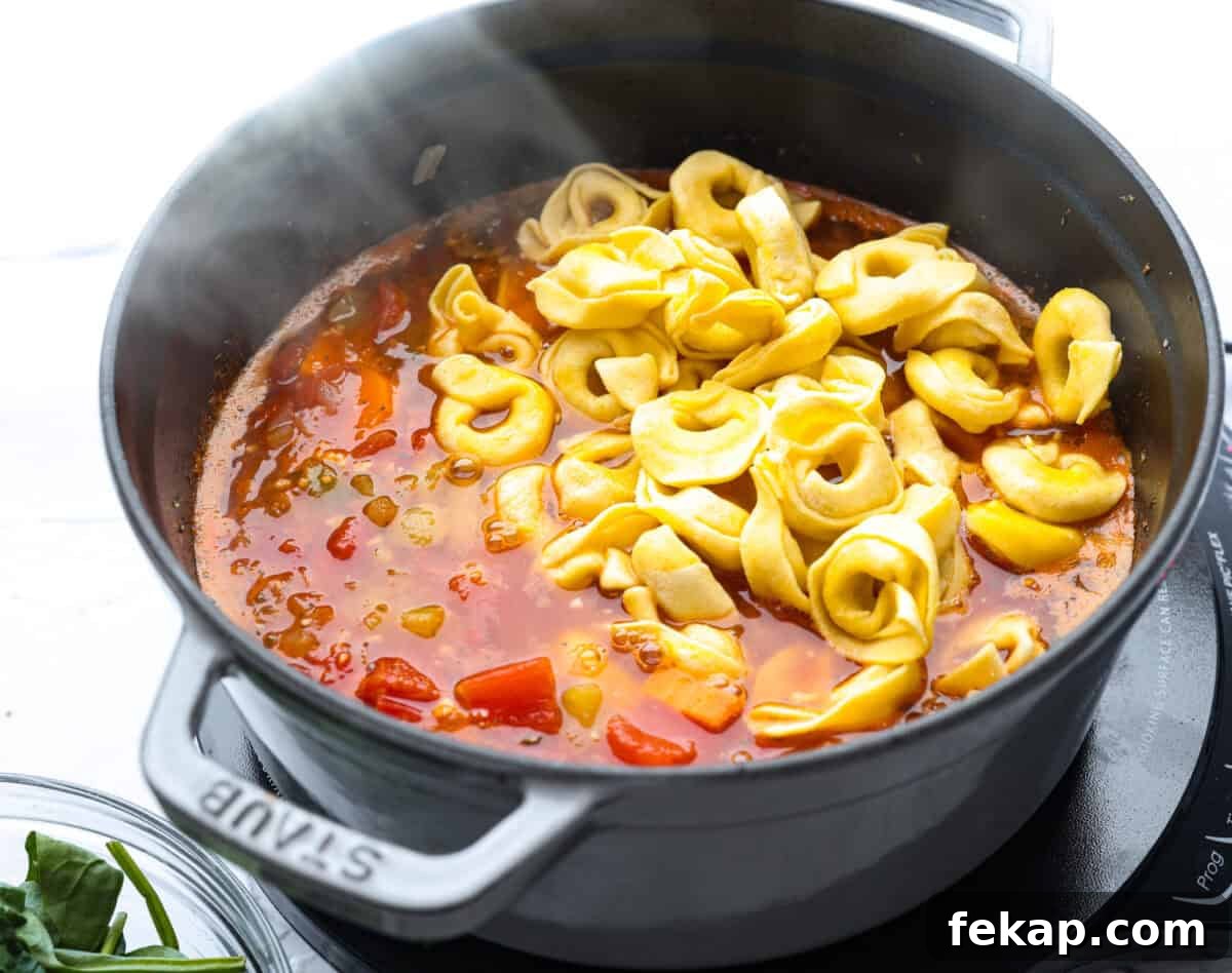 Tortellini added to the broth and veggie mixture.