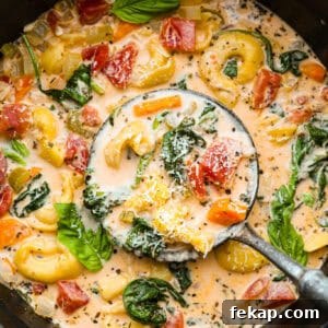 Creamy vegetable tortellini soup in a bowl.