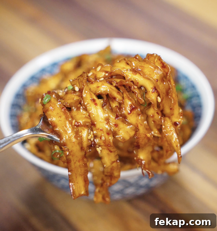 Spicy Chili Garlic Butter Noodles Recipe 3 A chopstick lift of saucy noodles, showing the glistening strands coated in chili garlic butter.
