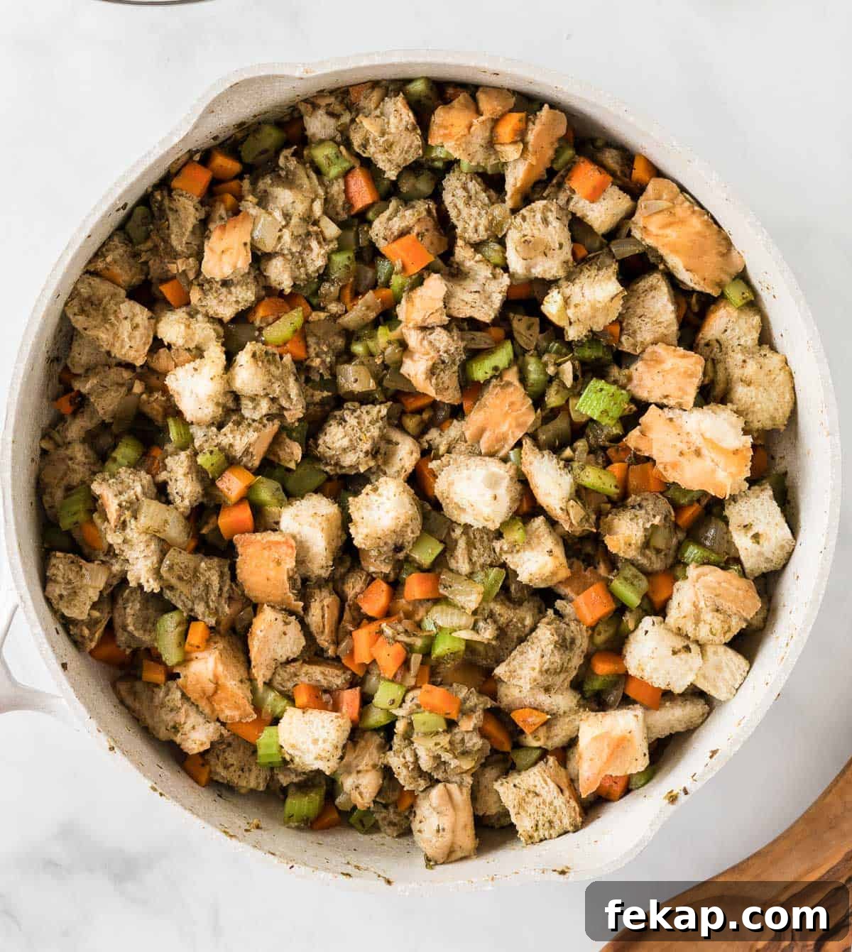 adding the toasted bread cubes and vegetable broth to the stuffing