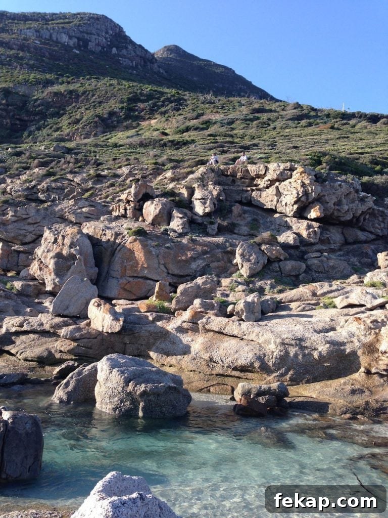 Leaving South Africa: Why I Said Goodbye 19 Fiance and friend climbing the rocks at Noordhoek Beach