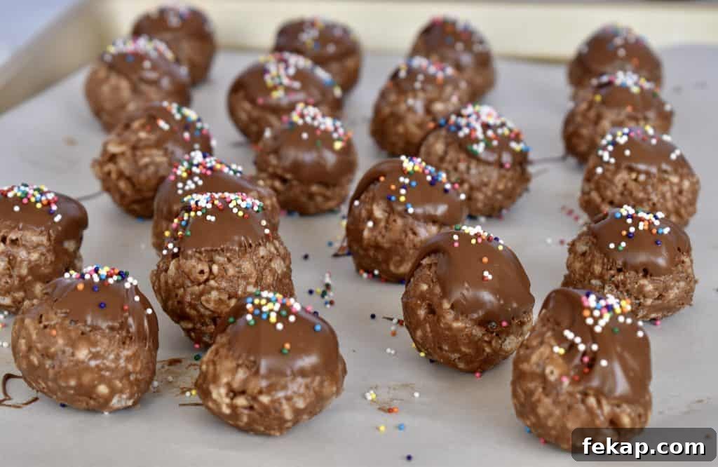 Chocolate topped Nutella balls with sprinkles on top on a cookie sheet.