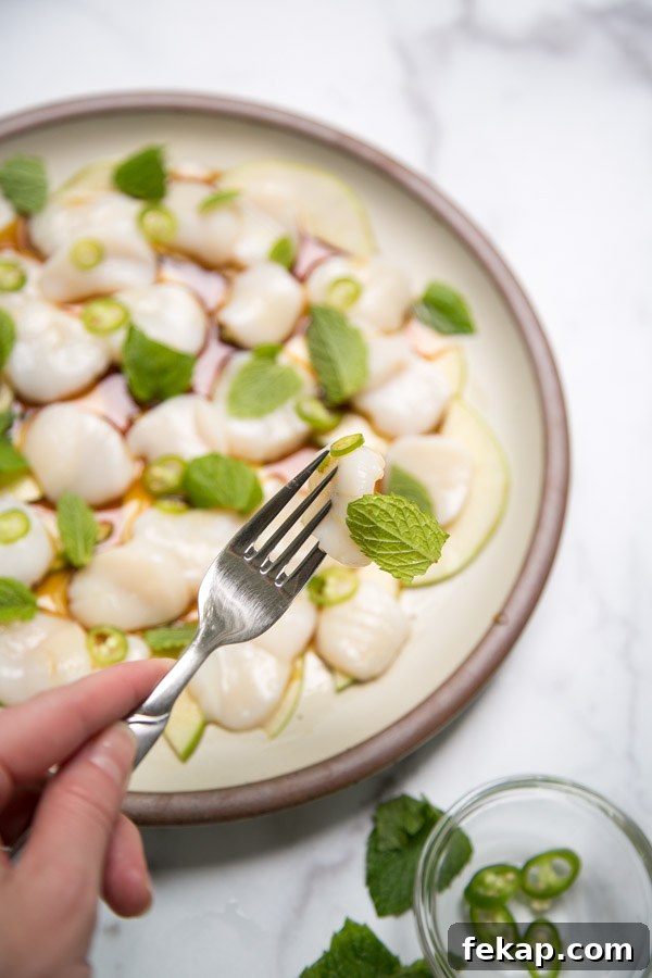 fork holding the best scallop crudo and mint