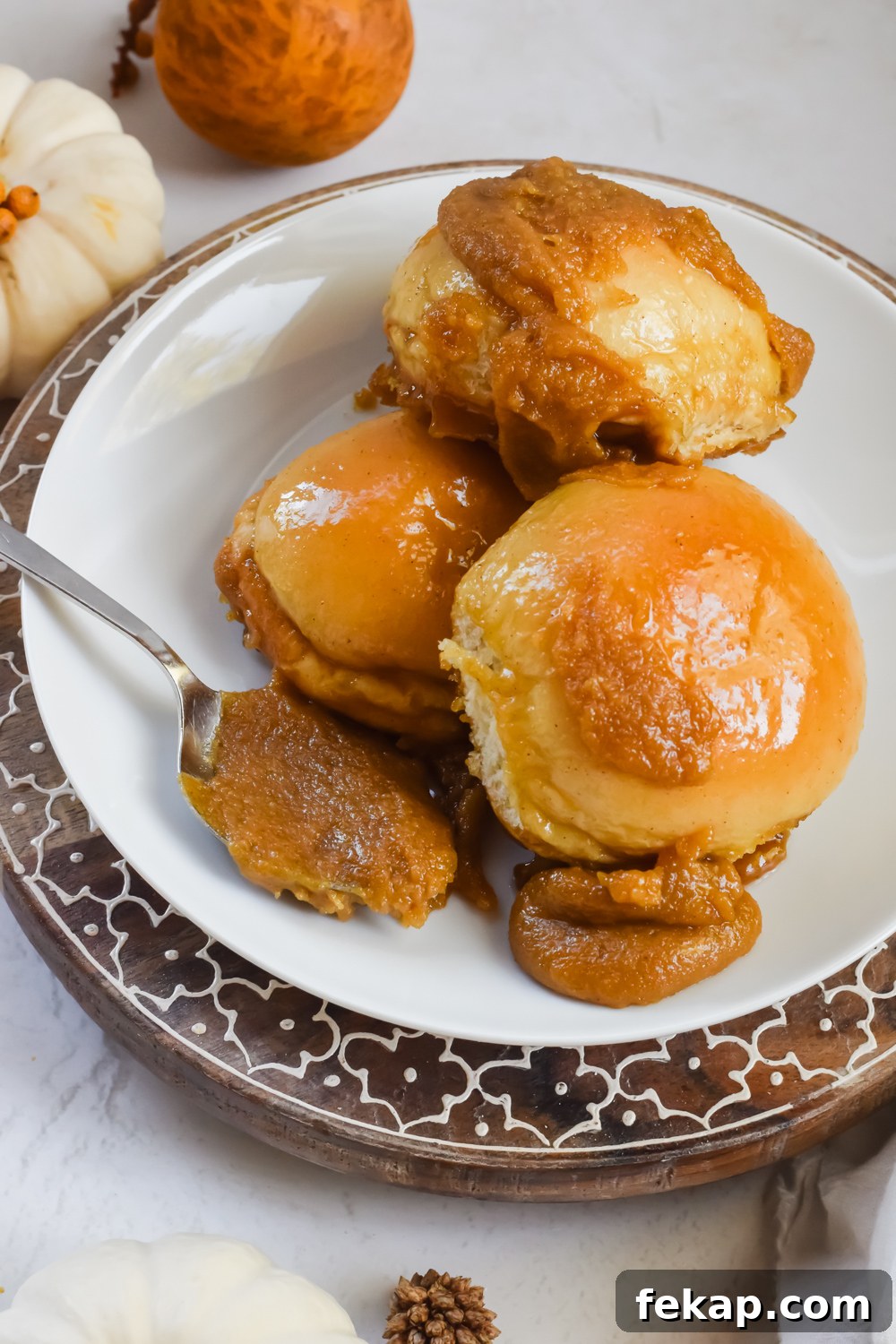 Classic Sticky Buns with Caramel Glaze 2 three baked old fashioned sticky buns stacked on top of eachother on white plate with extra caramel sauce added.