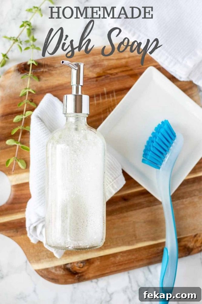 DIY Natural Dish Soap Recipe That Cuts Grease 2 homemade dish soap in a glass soap pump laying on a white wash cloth on a wood cutting board with a white dish to the right with a blue dish scrubber