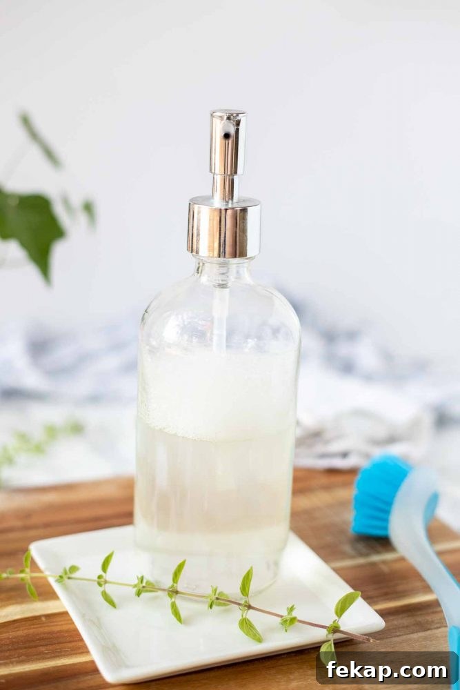 DIY Natural Dish Soap Recipe That Cuts Grease 3 diy dish soap in a glass soap pump jar on a white plate with oregano on a white plate