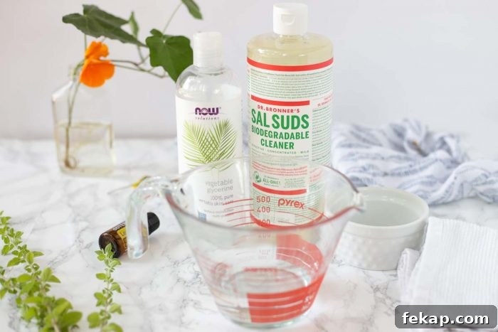 DIY Natural Dish Soap Recipe That Cuts Grease 4 homemade dish soap ingredients on a marble countertop with ivy in the background