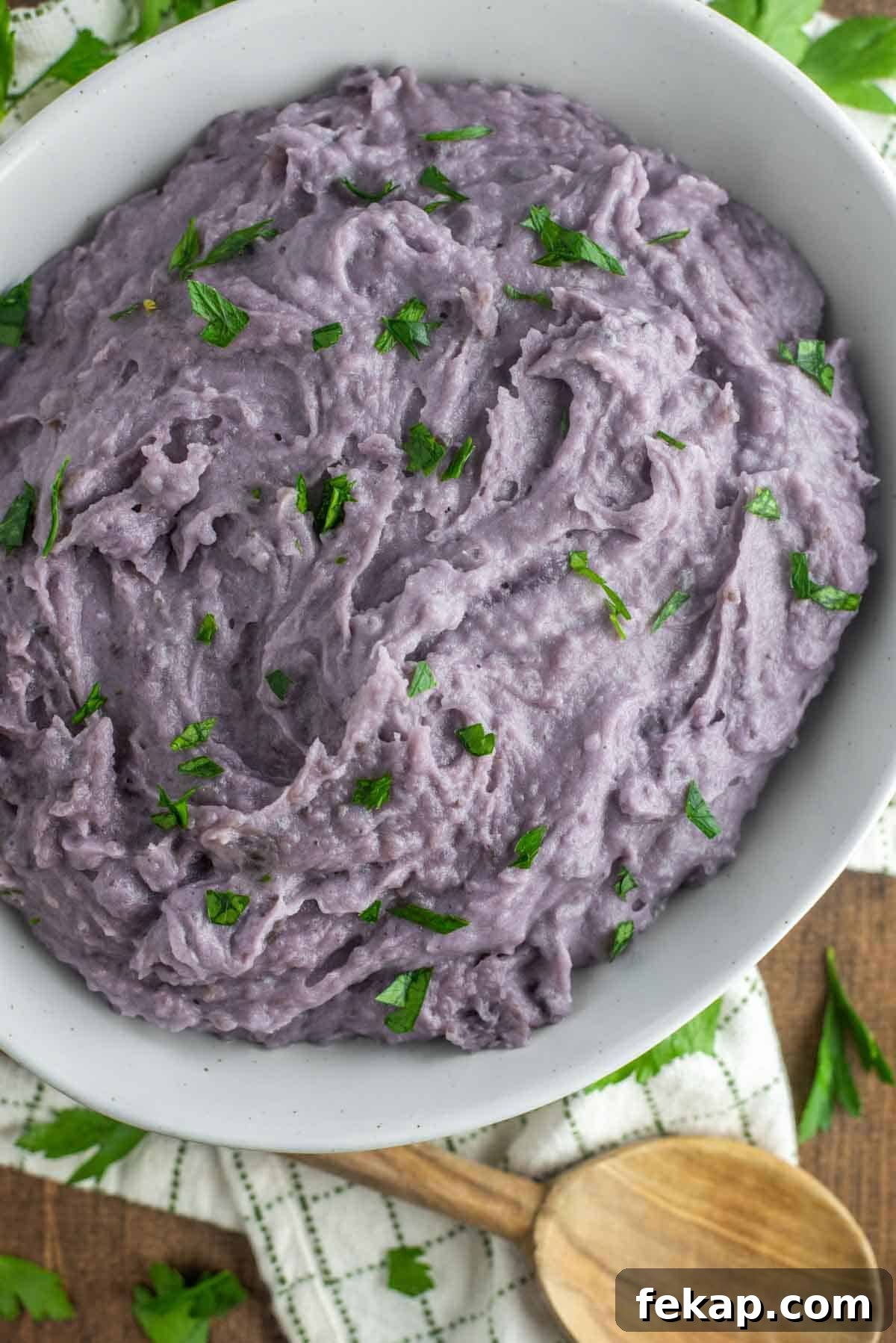 overhead shot of purple mashed potatoes in white bowl