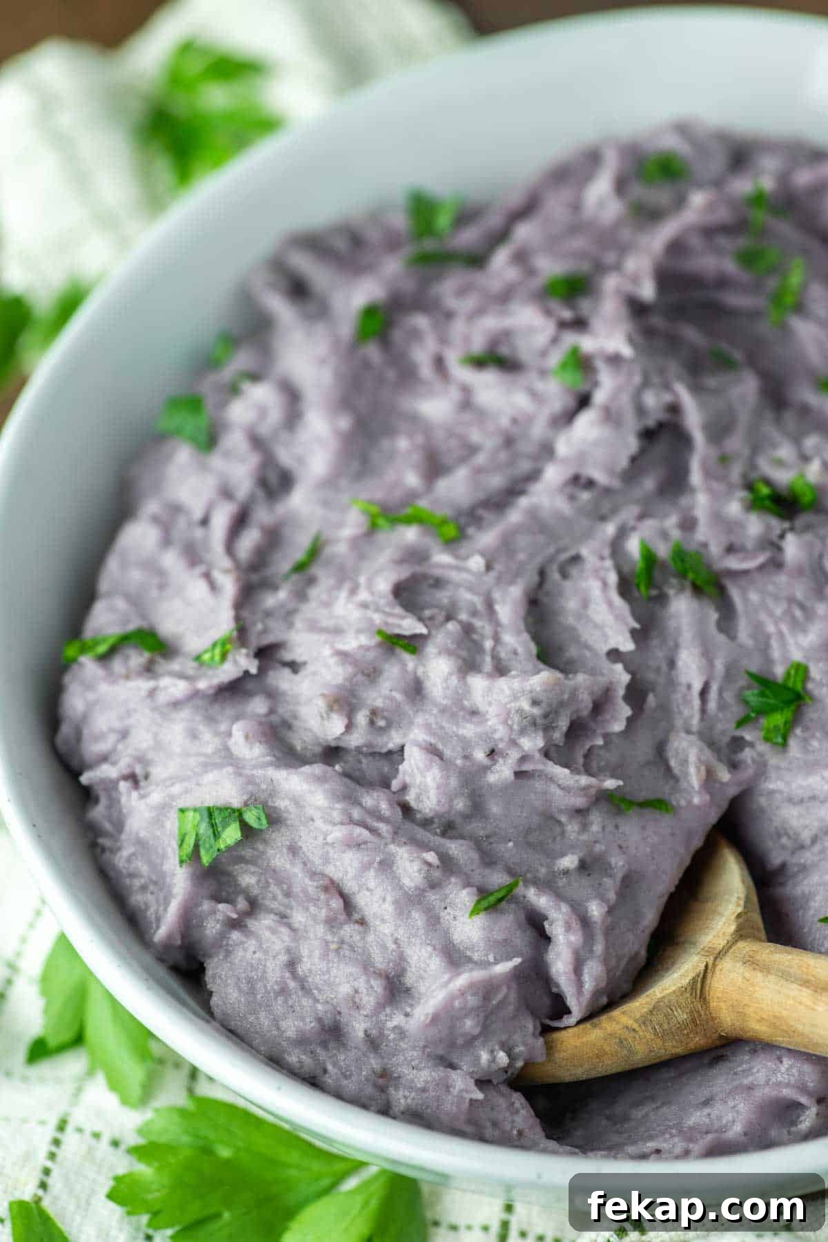 wooden spoon dipped in bowl of purple mashed potatoes