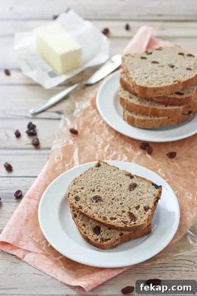 Quicker cinnamon raisin bread with warm cinnamon, sweet raisins, and only one rise. Several slices of quicker cinnamon raisin bread on white plates.
