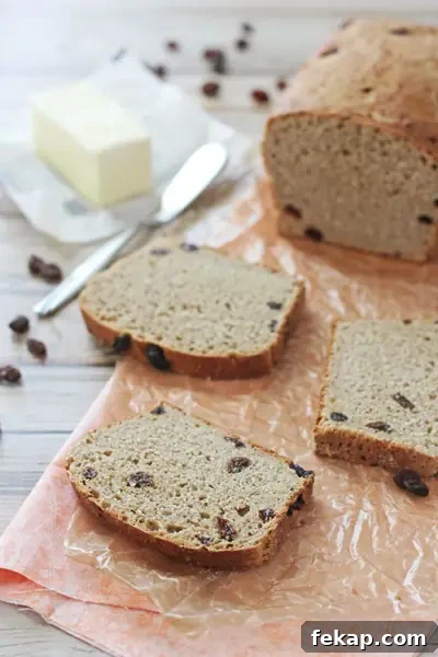 Quick cinnamon raisin bread that is soft, lightly sweet, and perfect for breakfast toast. Several slices of quick cinnamon raisin bread on parchment.
