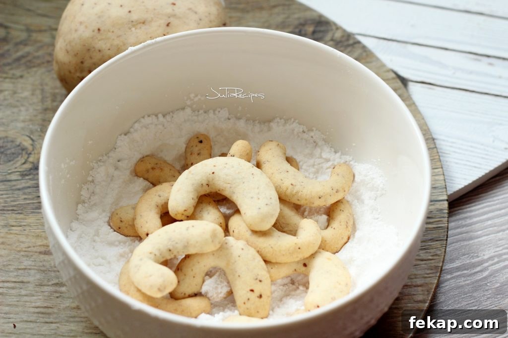 Vanilla Hazelnut Crescent Cookies 5 cookies in crescent shape in bowl of icing sugar