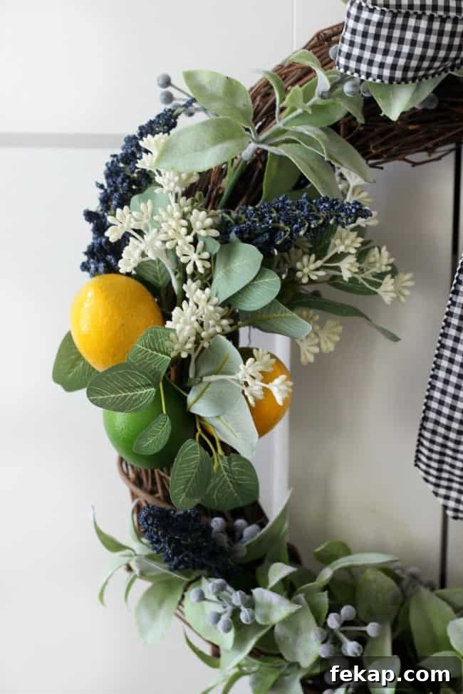 Bright pops of citrus, greenery and gingham combine for an adorable & easy citrus wreath to make this summer! citrus wreath side shot