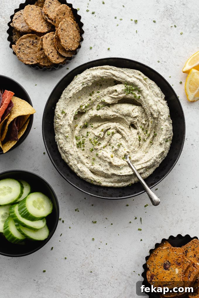 Creamy Vegan Herb Dip Recipe 7 Overhead view of vegan herb dip swirled around in a black bowl with a knife.