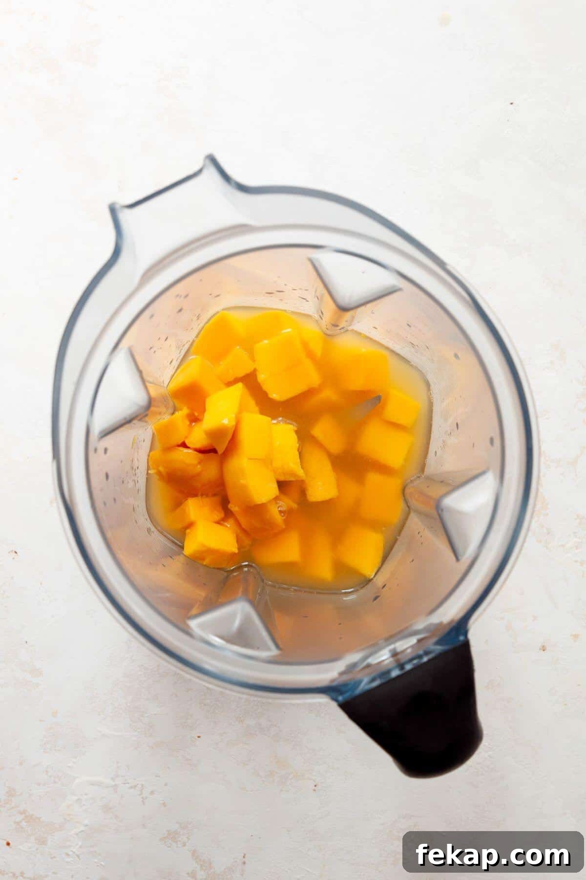 How to Make a Spicy Mango Margarita 6 Mangos, infused tequila, and lime juice in a blender.