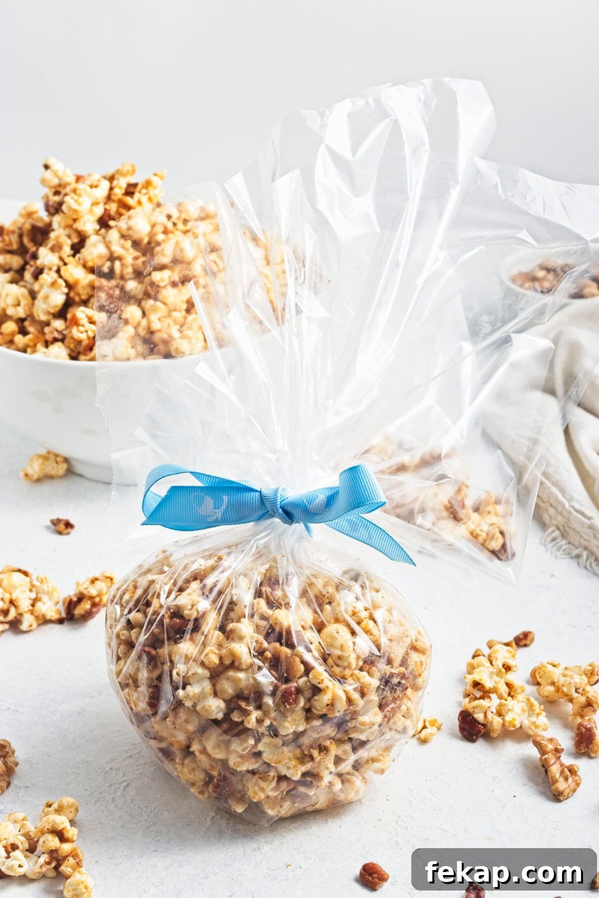 Homemade caramel popcorn wrapped in cellophane as a gift with a blue ribbon.