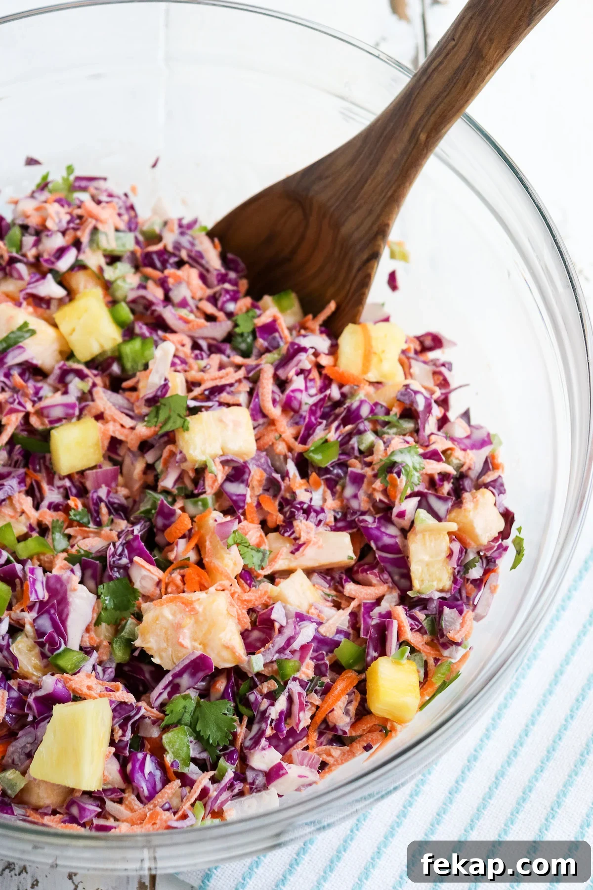bowl of prepared pineapple jalapeno coleslaw garnished with cilantro.