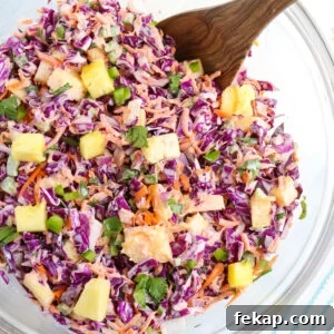 close up of prepared red coleslaw with visible tidbits of pineapple