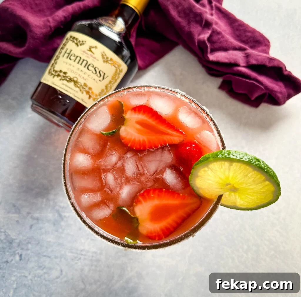 How to Make a Hennessy Margarita Cocktail 9 Hennessy margarita in a glass with strawberries and lime