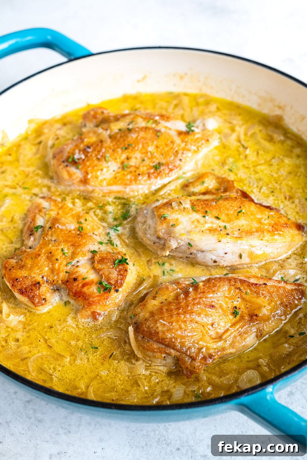 skillet with chicken breasts in french onion gravy