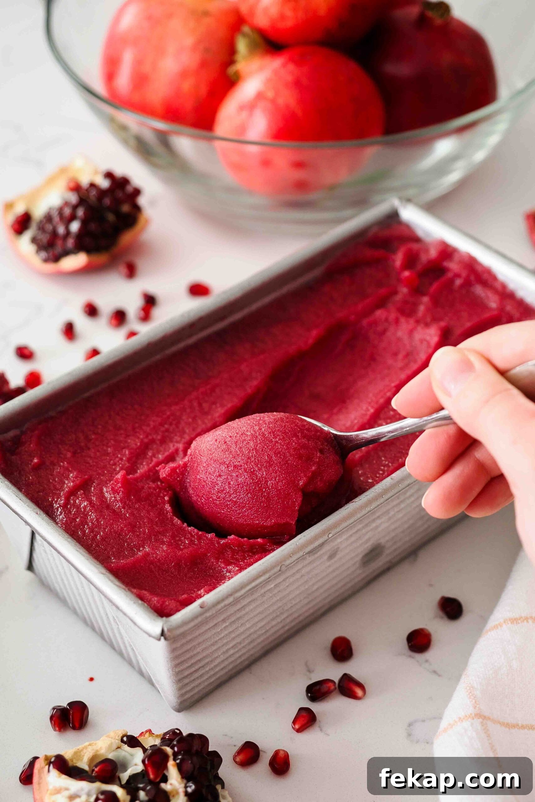 Homemade Pomegranate Sorbet Recipe 2 A teaspoon scoops up soft pomegranate sorbet from a loaf tin.